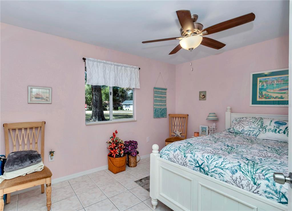 10901 Southwest 80th Court Ocala, FL 34481 - Photo 22 of 46 a bedroom with a bed and a chandelier