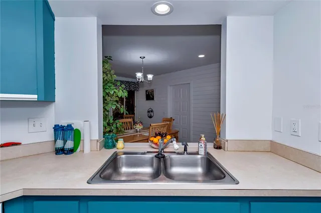 a kitchen with kitchen island a sink stainless steel appliances and a counter top space