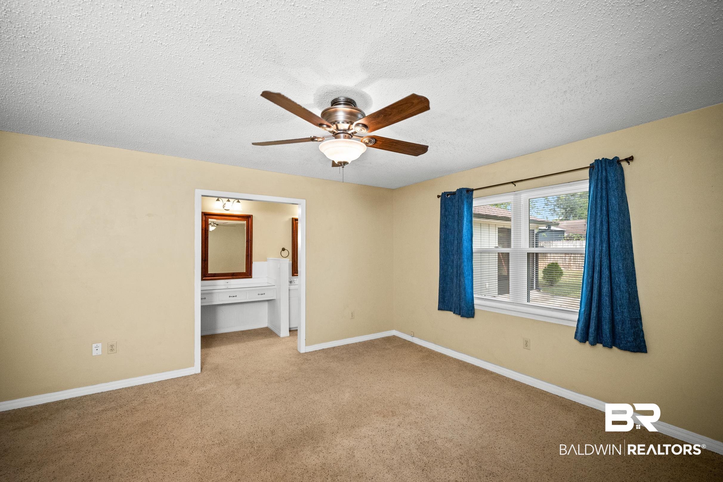 123 Dunbar Loop Daphne, AL 36526 - Photo 14 of 33 Unfurnished bedroom featuring a textured ceiling, ensuite bathroom, ceiling fan, and carpet flooring