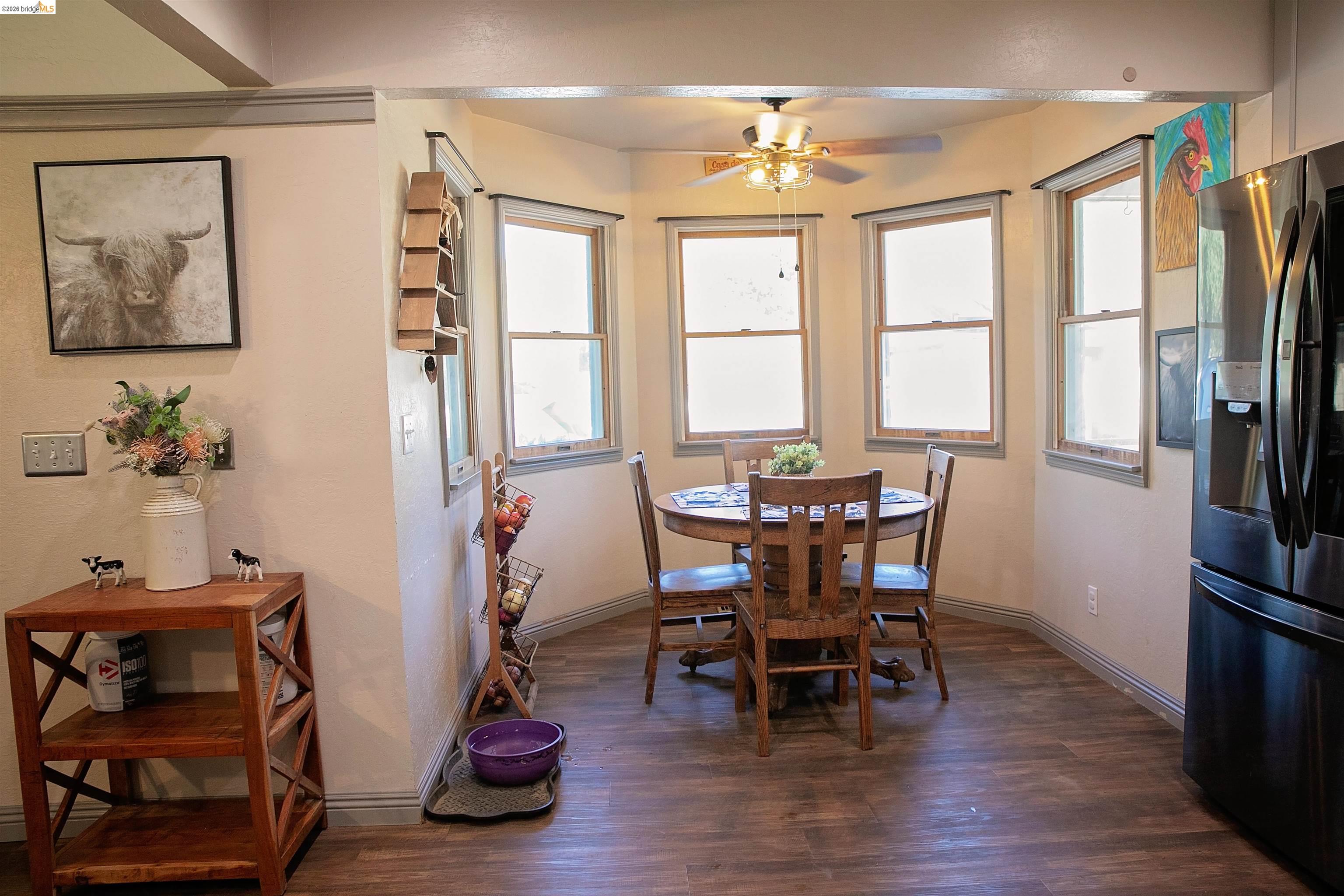 20982 Shaws Flat Road Sonora, CA 95370 - Photo 11 of 26 Dining area featuring wood-finish flooring and a bay window configuration with three vertical windows