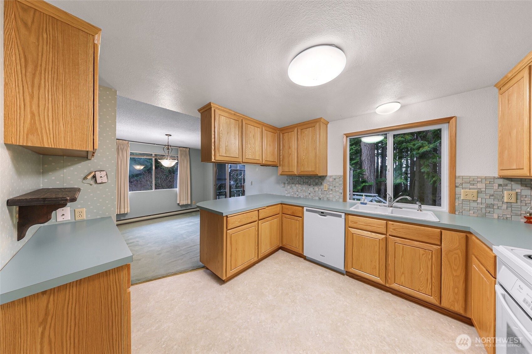 1834 Northeast Sumner Drive Oak Harbor, WA 98277 - Photo 12 of 37 a large kitchen with stainless steel appliances granite countertop a stove a sink dishwasher and a refrigerator with wooden cabinets