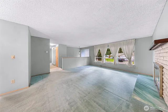 a view of an empty room with furniture and a fireplace