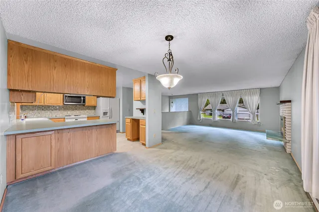 a view of kitchen with cabinets and window