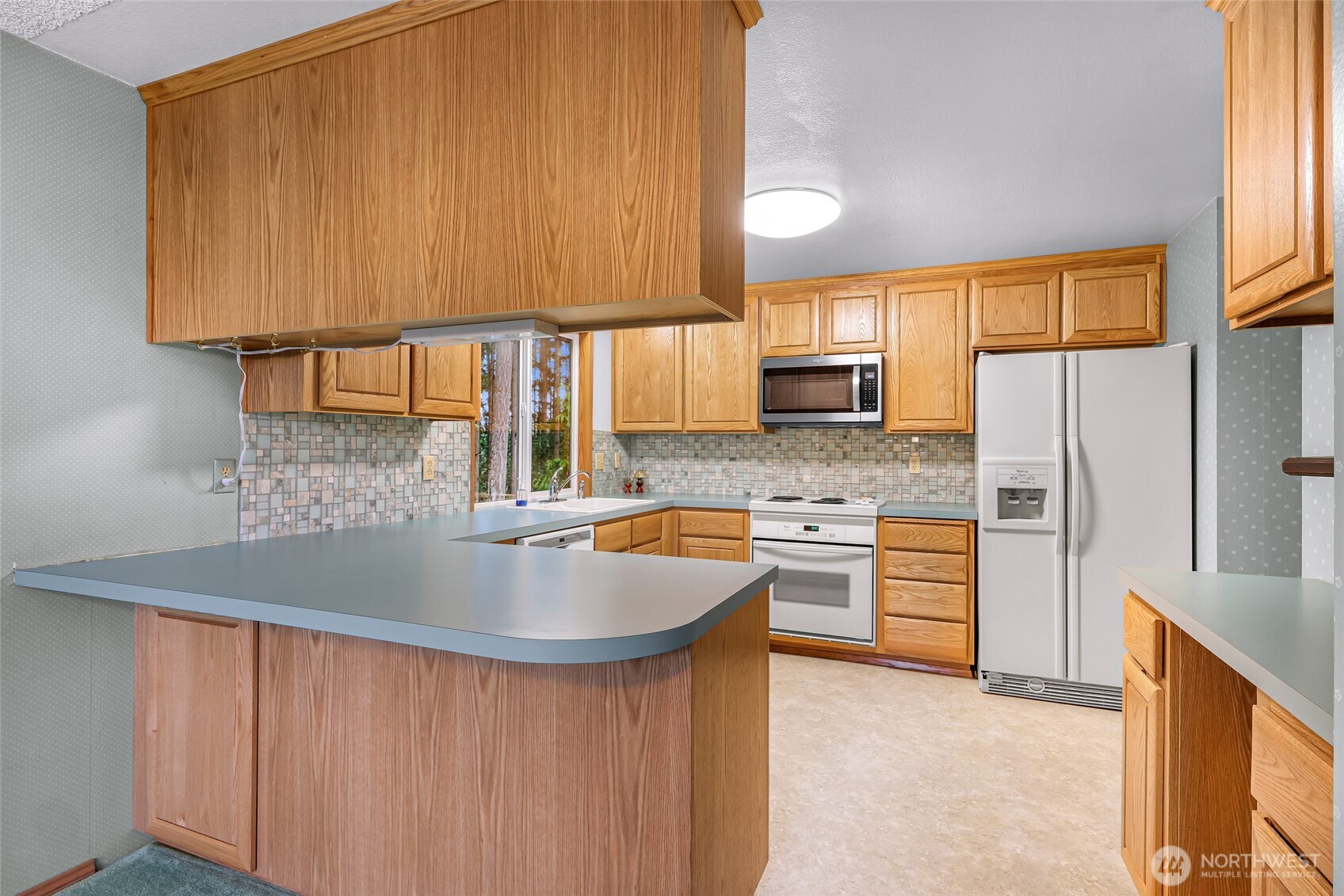 1834 Northeast Sumner Drive Oak Harbor, WA 98277 - Photo 9 of 37 a kitchen with stainless steel appliances granite countertop a sink a stove and a refrigerator