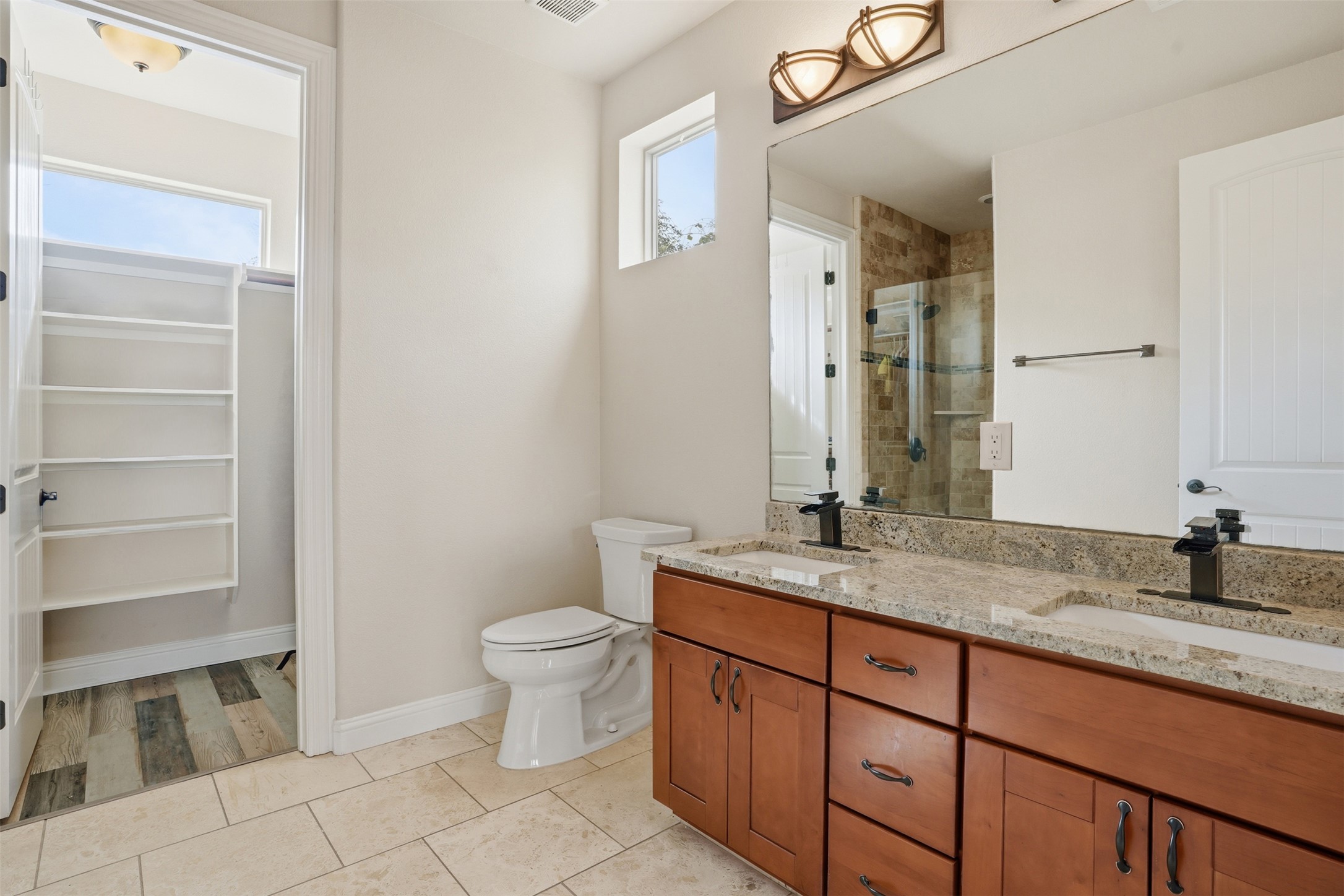 1185 Springdale Road Austin, TX 78721 - Photo 21 of 32 a bathroom with a granite countertop sink a toilet and a mirror