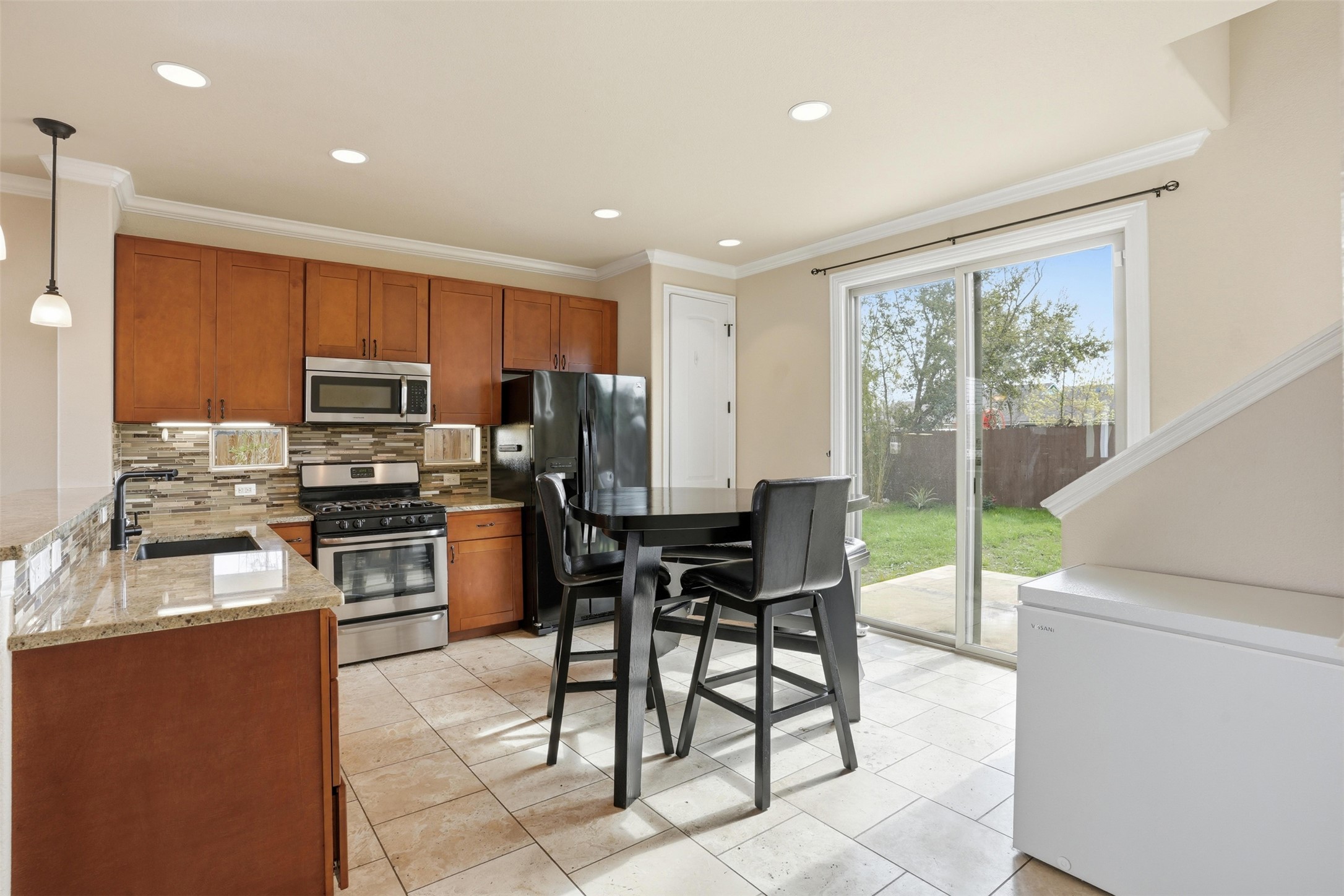 1185 Springdale Road Austin, TX 78721 - Photo 6 of 32 a kitchen with a table chairs microwave and refrigerator