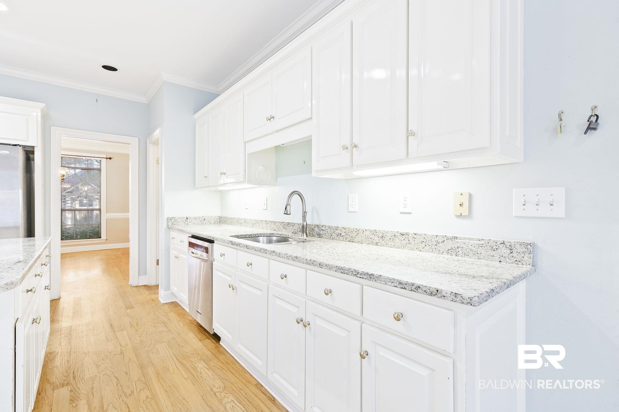 2100 Stonebrook Drive West Mobile, AL 36695 - Photo 17 of 60 Kitchen featuring sink, light stone counters, light hardwood / wood-style flooring, white cabinets, and appliances with stainless steel finishes