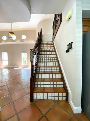 a view of an empty room with chandelier fan and a window