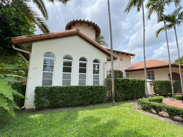 a view of a house with a yard and potted plants