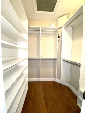 a room with walk in closet and wooden floor