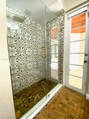 a view of an empty room with a window and kitchen view