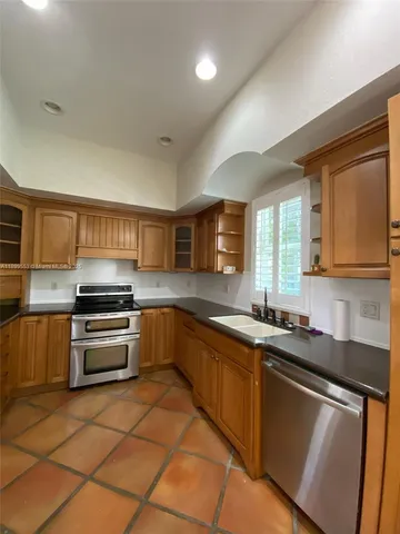 a kitchen with stainless steel appliances granite countertop a sink and stove top oven