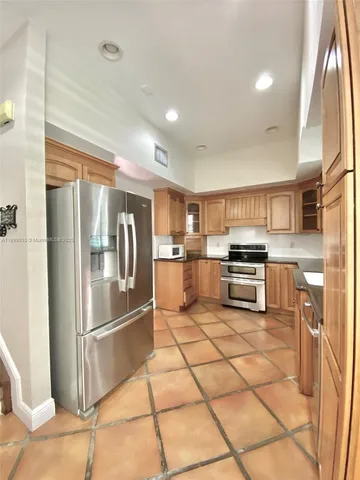 a kitchen with stainless steel appliances granite countertop a refrigerator and a stove top oven