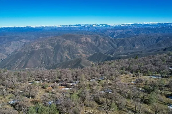 a view of a large mountain with trees in the background