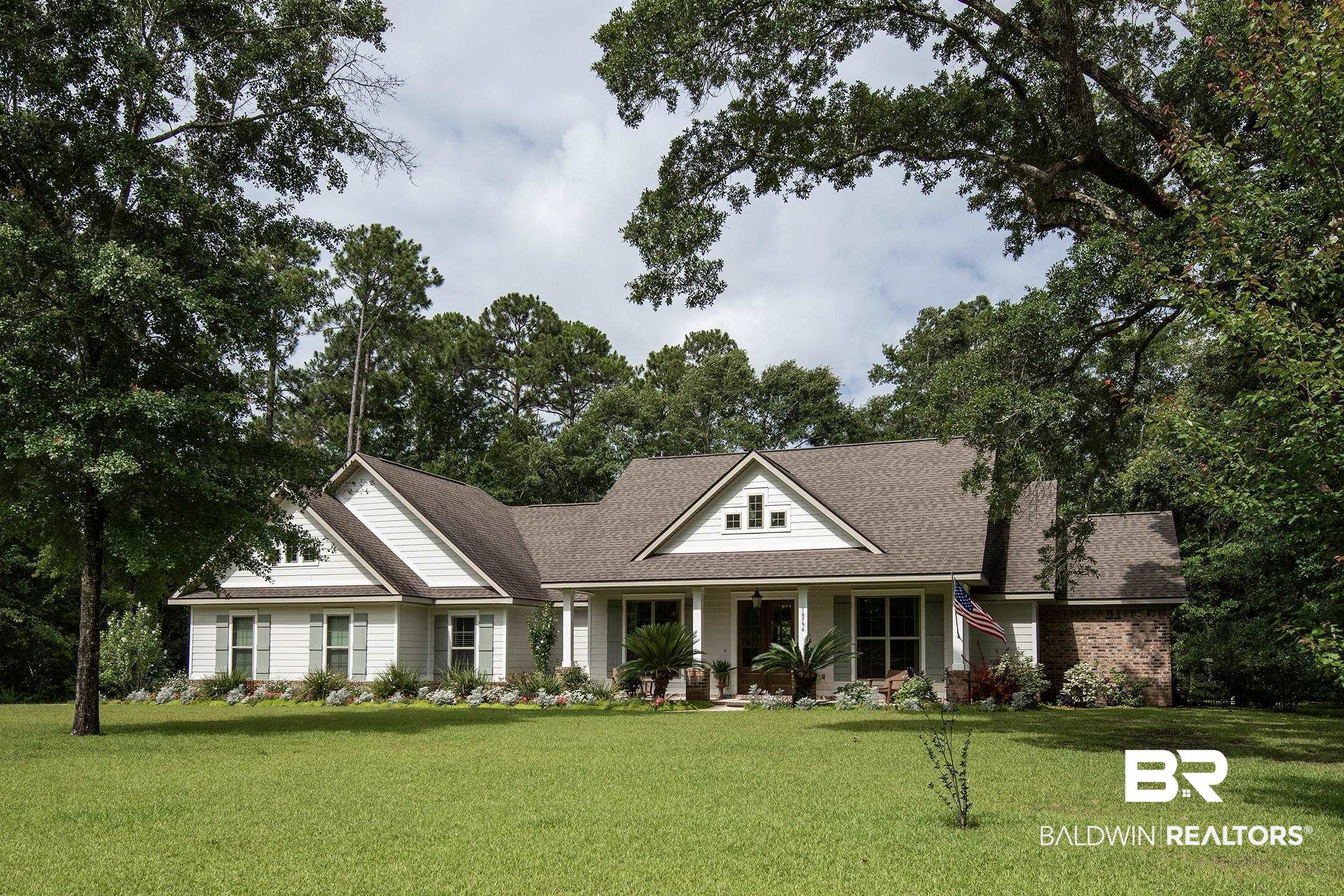 18754 Treasure Oaks Road Gulf Shores, AL 36542 - Photo 1 of 53 White siding exterior featuring multiple gables and a covered entry