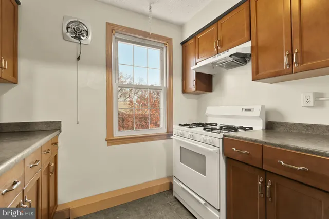 a kitchen with granite countertop white cabinets and white appliances