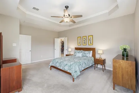 a spacious bedroom with a bed and a chandelier