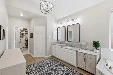 a spacious bathroom with a double vanity sink a mirror and a shower