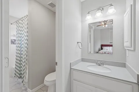 a bathroom with a granite countertop sink toilet and mirror