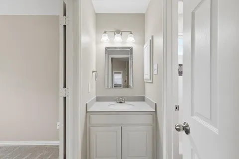 a bathroom with a granite countertop sink a mirror and a vanity
