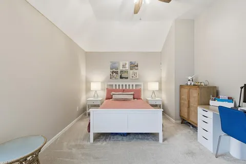 a bedroom with a bed and a lamp on the dresser