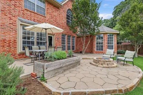 a patio with a table and chairs under an umbrella