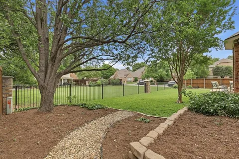 a view of a yard with a house and large trees