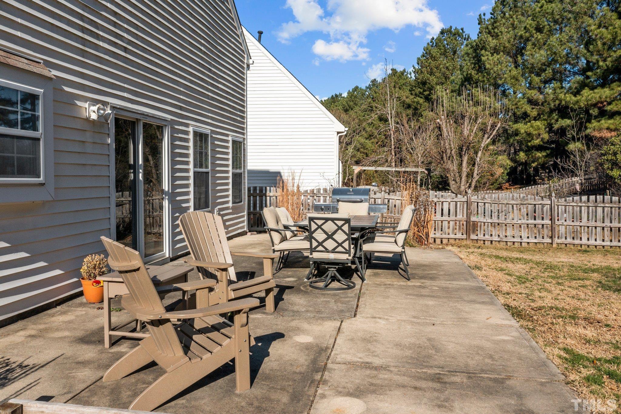 506 Ashford Lane Durham, NC 27713 - Photo 20 of 27 a view of a patio with table and chairs and wooden fence