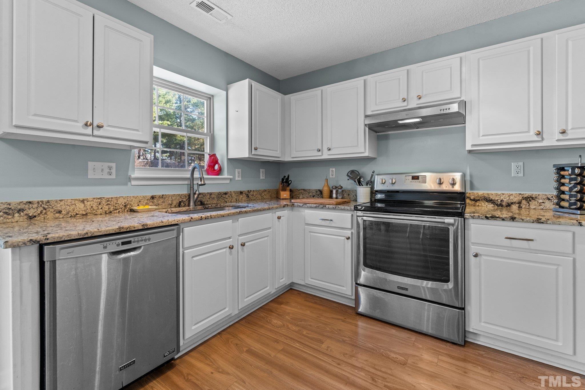 506 Ashford Lane Durham, NC 27713 - Photo 6 of 27 a kitchen with granite countertop white cabinets and white appliances