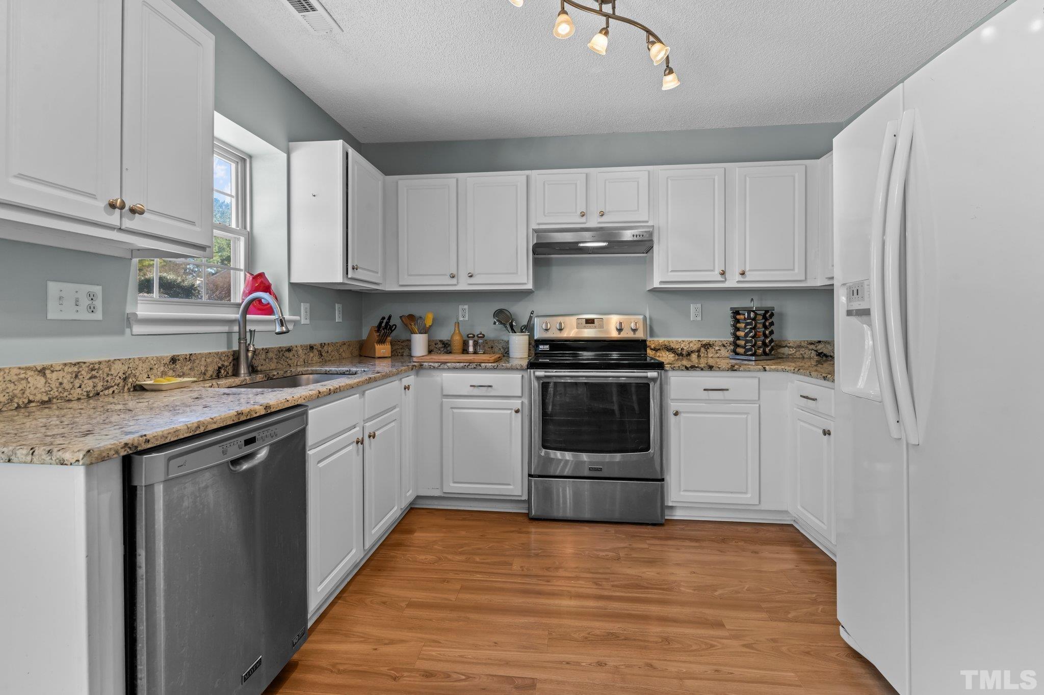 506 Ashford Lane Durham, NC 27713 - Photo 7 of 27 a kitchen with stainless steel appliances granite countertop a sink and cabinets