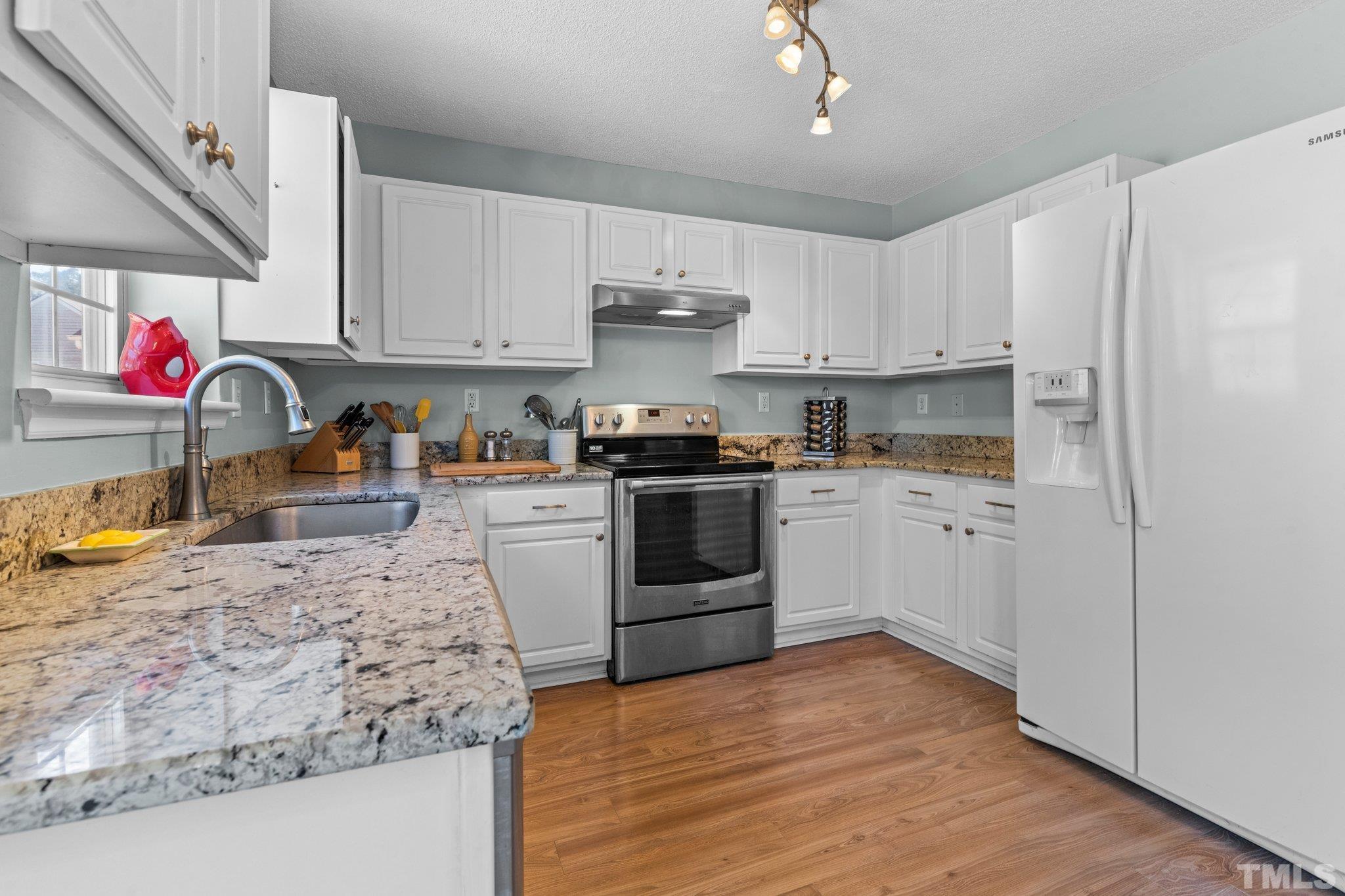 506 Ashford Lane Durham, NC 27713 - Photo 8 of 27 a kitchen with stainless steel appliances granite countertop a refrigerator sink and cabinets