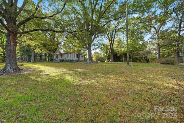 a front view of a house with a yard and trees