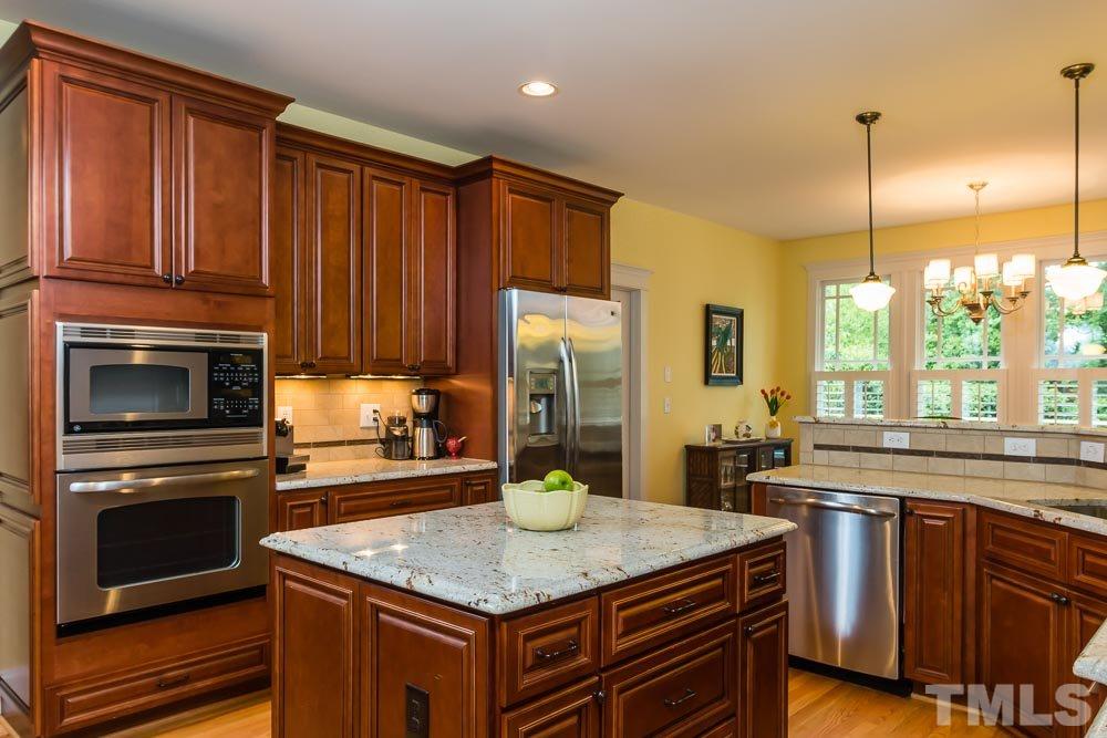 3048 Farrior Road Raleigh, NC 27607 - Photo 3 of 25 a kitchen with stainless steel appliances granite countertop a stove a sink dishwasher and a refrigerator with wooden cabinets