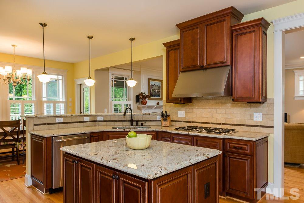 3048 Farrior Road Raleigh, NC 27607 - Photo 4 of 25 a kitchen with stainless steel appliances granite countertop a stove a sink dishwasher and cabinets with wooden floor
