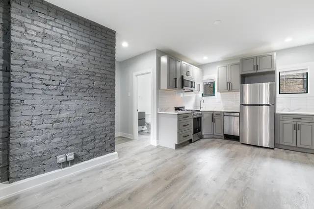 a kitchen with stainless steel appliances a refrigerator and a stove top oven