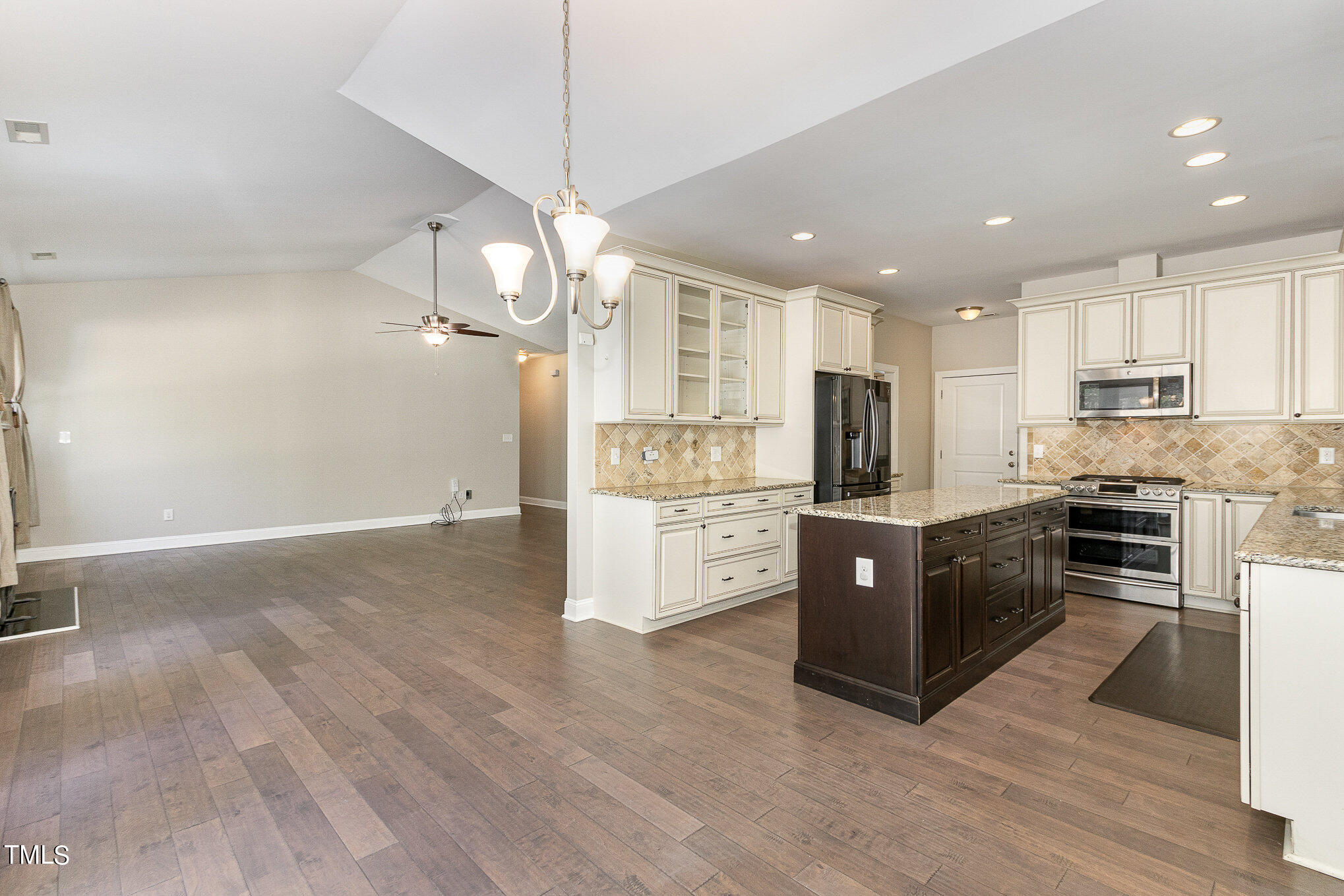 3640 Pineview Circle Durham, NC 27705 - Photo 15 of 41 a large kitchen with stainless steel appliances granite countertop a stove a sink dishwasher a refrigerator white cabinets and wooden floor next to a window