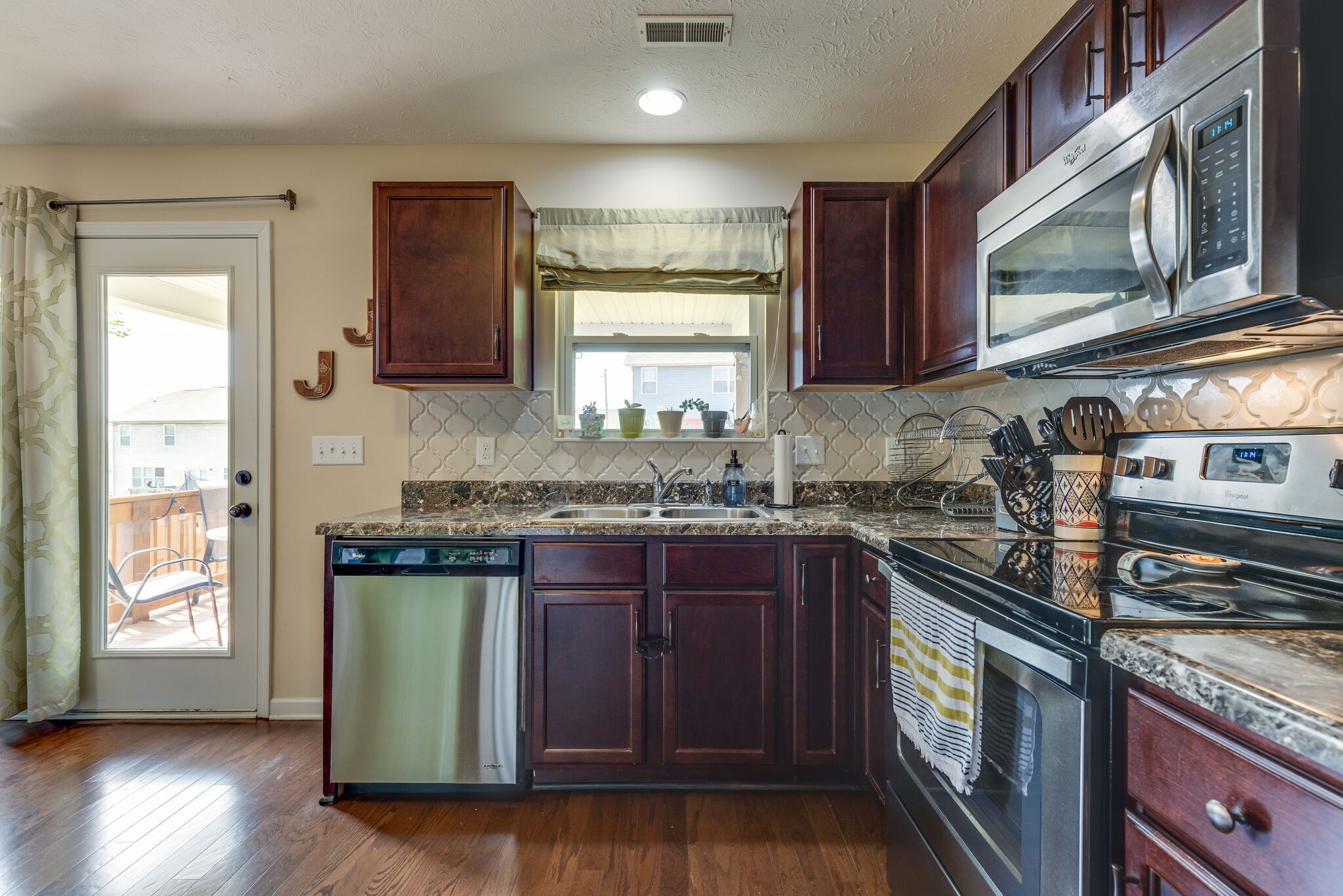 4757 Backstretch Boulevard Antioch, TN 37013 - Photo 16 of 39 a kitchen with stainless steel appliances granite countertop a stove a sink and a microwave