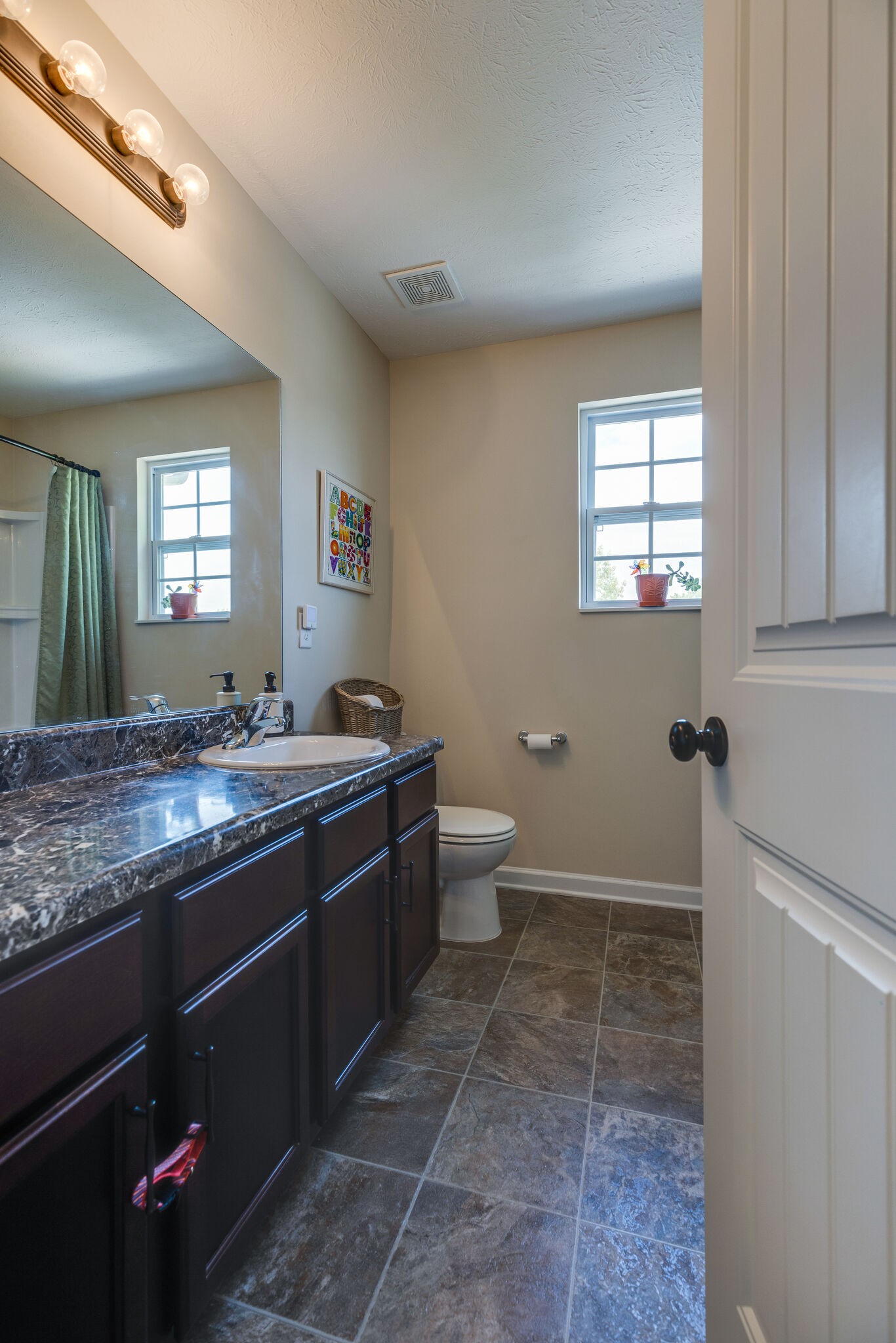 4757 Backstretch Boulevard Antioch, TN 37013 - Photo 19 of 39 a bathroom with a granite countertop sink a toilet and a mirror