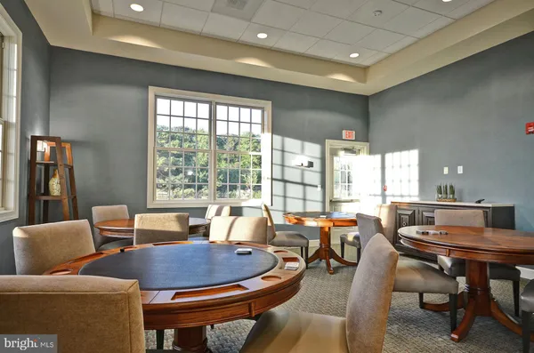 a living room with couches and a dining table with a mirror