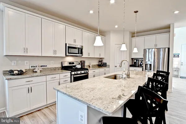 a kitchen with stainless steel appliances granite countertop a sink refrigerator and cabinets