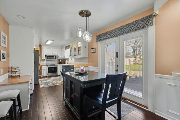 a dining room with furniture a chandelier and wooden floor