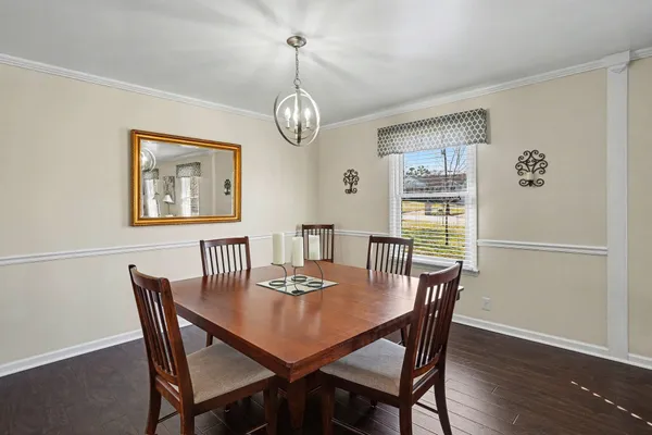 a view of a dining room with furniture wooden floor and a chandelier