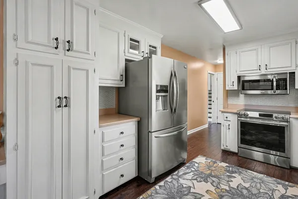 a kitchen with cabinets stainless steel appliances and a counter space