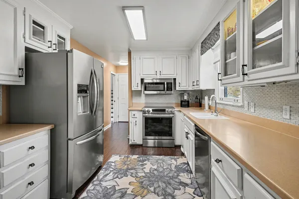 a kitchen with stainless steel appliances granite countertop a refrigerator stove and sink