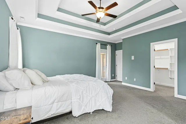 a bedroom with a large bed chandelier and a window