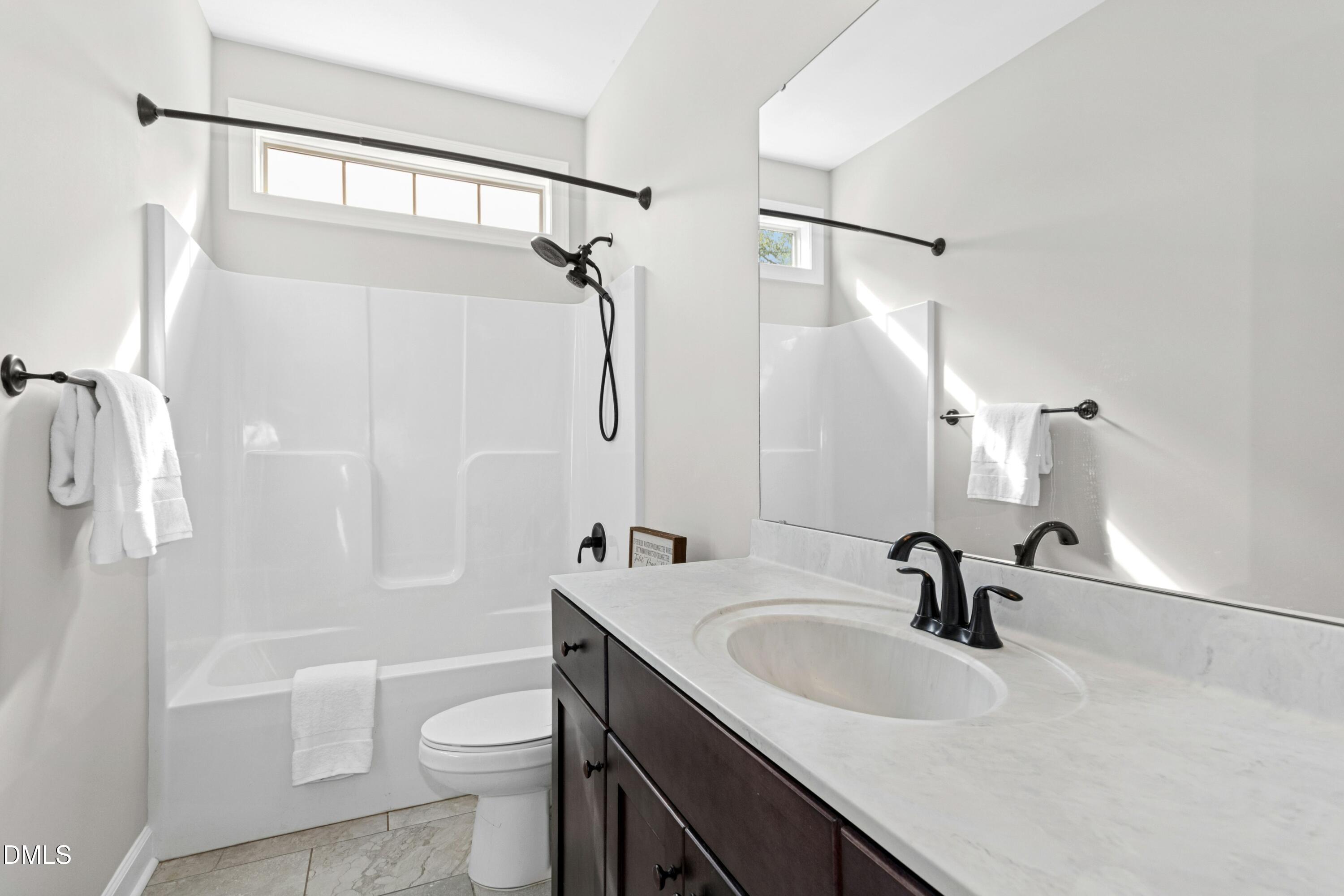 165 Thunder Ridge Drive Garner, NC 27529 - Photo 27 of 32 a bathroom with a sink a toilet and a mirror