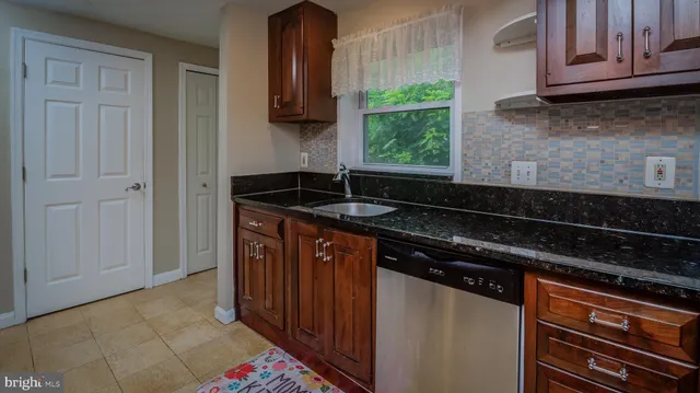 a kitchen with granite countertop a sink and a stove