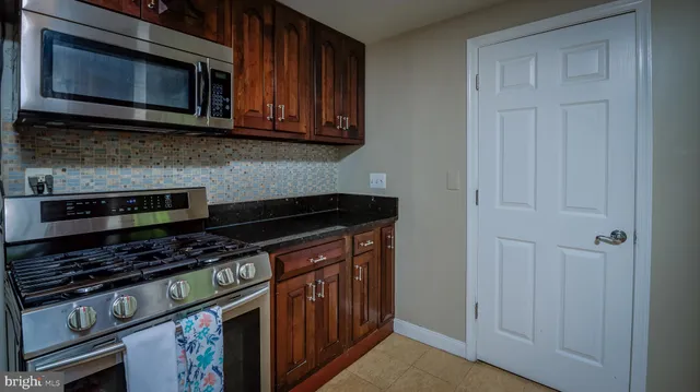 a kitchen with stainless steel appliances granite countertop a stove microwave and oven
