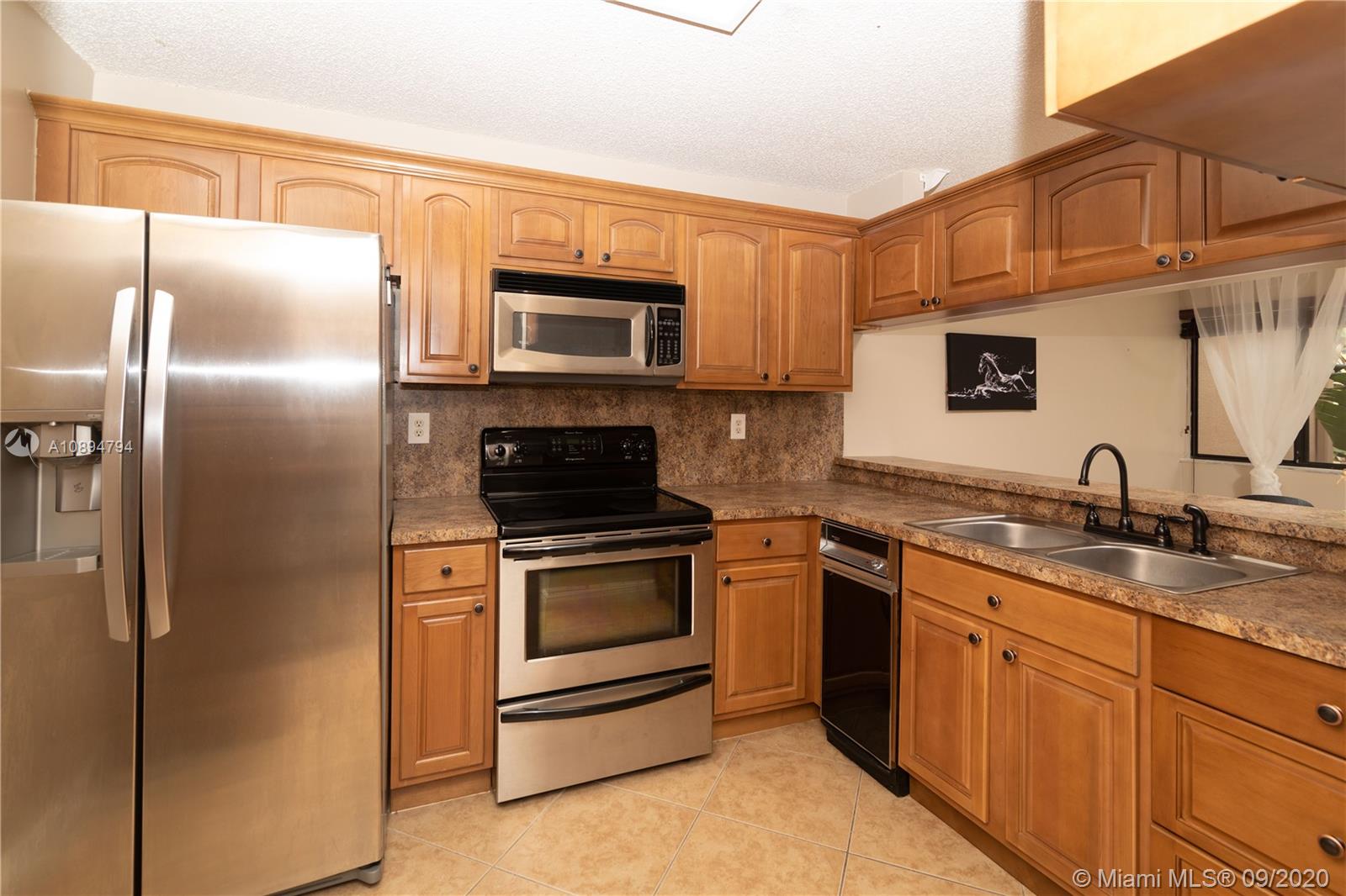 a kitchen with stainless steel appliances granite countertop a refrigerator stove top oven a sink and dishwasher