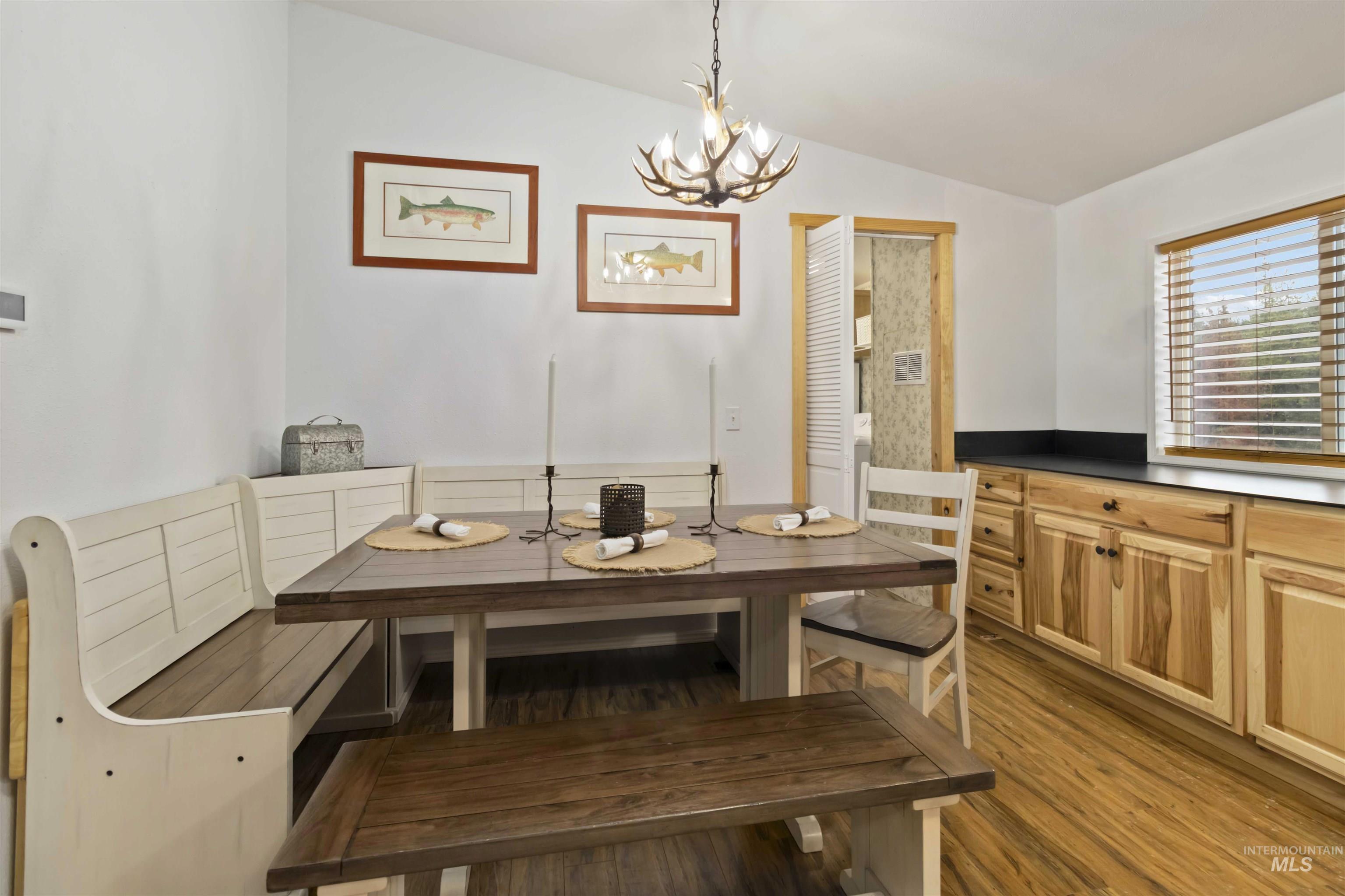 9592 Packer John Road Cascade, ID 83611 - Photo 14 of 47 Dining room with wood finished floors, a chandelier, and vaulted ceiling